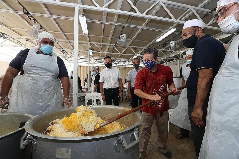 BERIANI SEDAP TIDAK TERKATA: Tetamu terhormat acara pengedaran beriani, Encik Edwin Tong, semalam mengacau nasi beriani terkenal Masjid Khalid sambil disaksikan pengerusinya Encik Alla'udin Mohamed (dua dari kanan) dalam kerjasama sulung ETF dan masjid tersebut. Turut bersama mereka ialah mayor CDC South East Fahmi Aliman (dua dari kiri) dan pengerusi jawatankuasa ETF Abdul Razak Hassan Maricar (tiga dari kiri). - Foto BM oleh TIMOTHY DAVID
