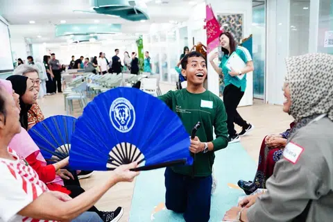 Penolong Pengarah Projek BeKhayr, Encik Muhamad Danial Roslan (tengah), mengajar warga emas menggunakan alat kipas dalam seni silat.
