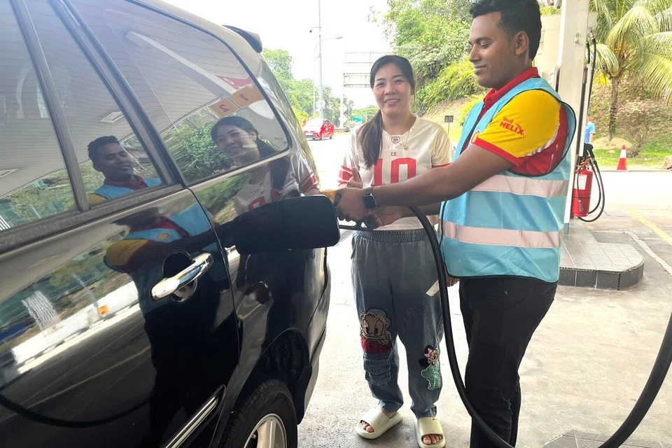 Wanita warga Vietnam, Cik Nguyen Thi Ny, 40 tahun (kiri), yang berkahwin dengan warga Malaysia, perlu membayar harga petrol RON95 tanpa subsidi RM2.60 seliter untuk kenderaannya. 