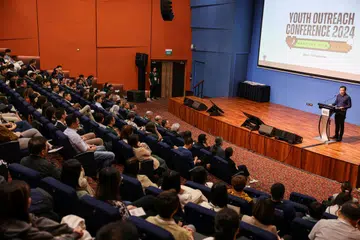 Setiausaha Parlimen Kanan (Pembangunan Sosial dan Keluarga), Encik Eric Chua (kanan), ketika berucap semasa Persidangan Khidmat Belia di Universiti Nasional Singapura (NUS) pada 25 September.