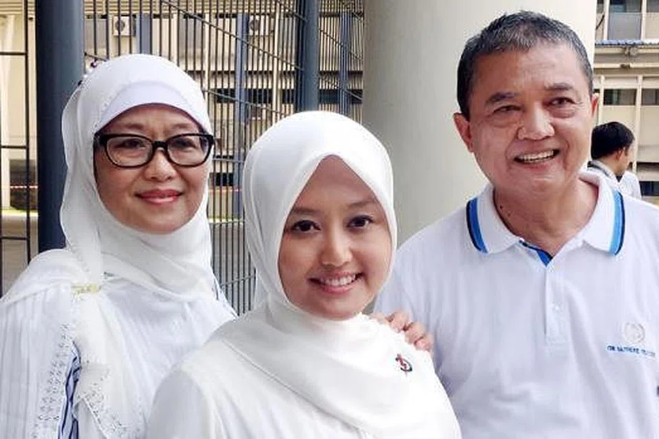 SOKONGAN KUAT KELUARGA: Calon baru Parti Tindakan Rakyat (PAP) bagi GRC Jurong, Cik Rahayu Mahzam, mendapat sokongan ayahnya, Haji Mahzam Mohamed, dan ibunya, Hajah Kasmawati Manijan. Tiada dalam gambar ialah ibu bapa mentua dan dua adiknya yang turut hadir di Sekolah Rendah Keming semasa Hari Penamaan Calon semalam. - Foto MUHAMMAD KHAIRULAMEER RAMLAN