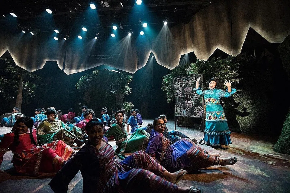 PENGLIPUR LARA: Watak MakAndir yang bijaksana, lakonan Siti Khalijah Zainal (berdiri), dalam konteks masyarakat tradisional, memberi suntikan pembaharuan dan jaminan tentang peranan penting kaum Hawa dalam kepimpinan masyarakat dalam pementasan Alkesah di Esplanade pada Pesta Raya 2018. - Foto fail