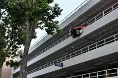 TERGANTUNG KELUAR: Sebahagian depan kereta Volkswagen Beetle ini telah merempuh sebahagian dinding parapet di tingkat empat tempat letak kereta ini.