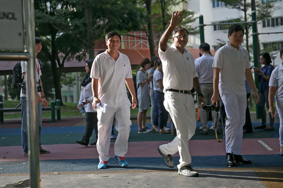 TINJAU KAWASAN: Encik Murali Pillai (melambai) dirakam berjalan di Bukit Batok West Avenue 6 awal bulan ini. - Foto THE STRAITS TIMES