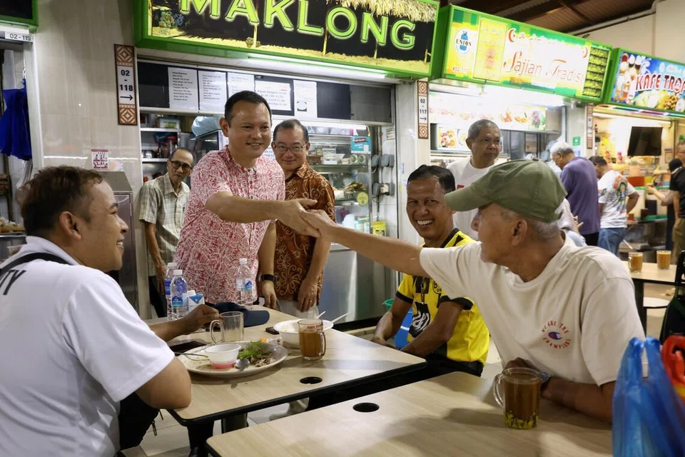 Pemangku Menteri Bertanggungjawab bagi Ehwal Masyarakat Islam, Encik Zaqy Mohamad (diri, kiri) dan Speaker Parlimen yang juga merupakan Anggota Parlimen (AP) bagi GRC Marine Parade-Braddell Heights, Encik Seah Kian Peng, (diri, tiga dari kiri) beramah tamah dengan pengunjung di Pusat Penjaja dan Pasar Geylang Serai pada 26 Julai.