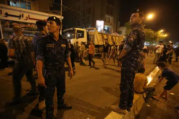 LETUPAN BOM KERETA: Pasukan keselamatan Iraq berjaga-jaga di tapak serangan bom kereta yang berlaku awal pada 3 Julai 2016 di kejiranan Karrada di Baghdad. 