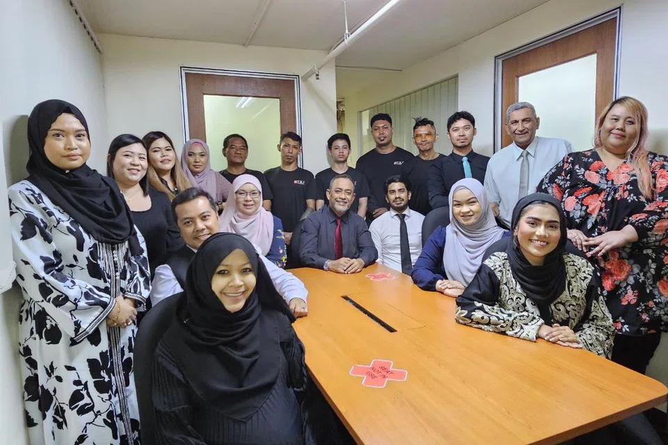 SEMANGAT WAJA: Pengarah syarikat POS TKI Logistics Pte Ltd, Encik Mohamed Anwar Tahar (duduk tengah) bersama kakitangannya termasuk penolong pengurus besar syarikat, Cik Roziana Ibrahim (duduk tiga dari kiri); pengurus pembangunan perniagaan syarikat, Encik Mohamed Farhan Anwar (duduk tiga dari kanan); dan pengurus operasi syarikat, Encik Sahmil Isa (duduk dua dari kiri).