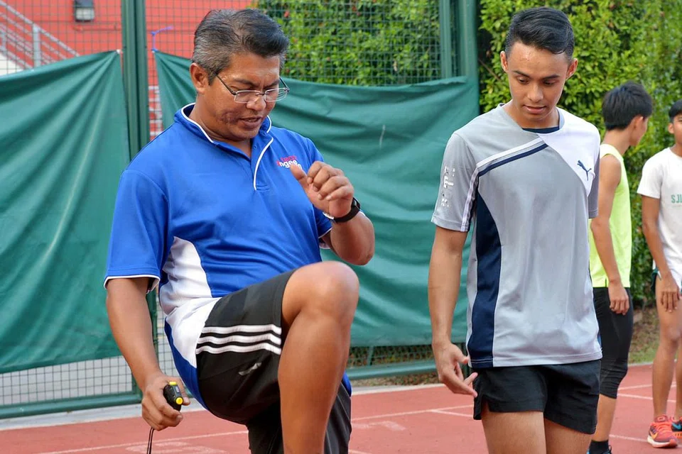 TUNJUK AJAR: Suhairi (kanan) melihat teknik yang ditunjukkan jurulatihnya yang juga bekas jaguh perlumbaan pecut negara, Muhamad Hosni Muhamad, semasa di sesi latihan baru-baru ini. - Foto TUKIMAN WARJI 