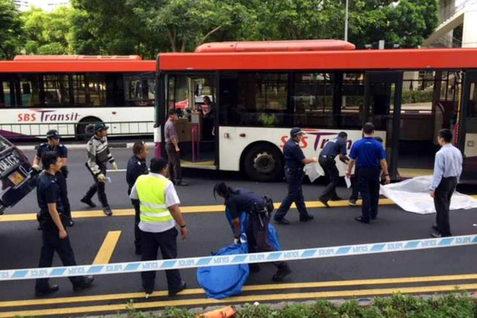 TUTUP MAYAT: Polis menutup mayat seorang warga tua yang meninggal dunia selepas dilanggar sebuah bas di luar pusat pertukaran bas Toa Tayoh pagi semalam. - Foto THE STRAITS TIMES