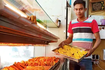 KEDAI KARIPAP 'BAI' JUGA ADA DI ESTET-ESTET HDB: Pekerja D'Snack Corner, Encik Shamir Mohamed, menyusun karipap dikedai milik Encik Yusof Ani Mustafa di Tampines. - Foto BM oleh SAINI SALLEH.