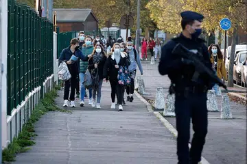 TINGKAT KAWALAN KESELAMATAN: Seorang anggota polis Perancis berdiri dekat pintu masuk sekolah menengah Le Bois d'Aulne di Conflans-Sainte-Honorine, yang terletak kira-kira 30km di barat laut Paris, pada 3 November lalu. - Foto AFP