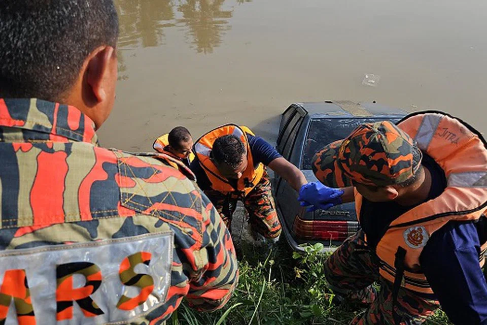 Anggota bomba sedang menarik kereta Proton Saga Iswara yang tenggelam dalam Sungai Korok, Jitra, Kedah.