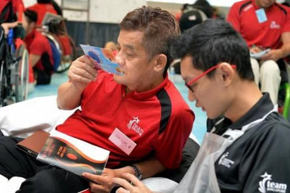 TIMBA PENGALAMAN: Hasim (kiri) senang hati dapat berinteraksi dengan atlit Team Singapore di perkhemahan itu. 