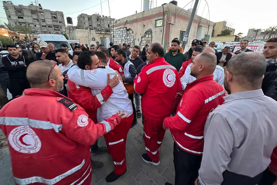 Kakitangan kecemasan berpelukan antara satu sama lain di Kompleks Perubatan Nasser di Khan Yunis, selatan Semenanjung Gaza, pada 30 Mac, ketika mayat responden pertama Palestin yang terbunuh seminggu sebelumnya dalam tembakan tentera Israel, dibawa ke kemudahan itu. 