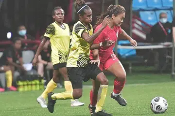 TUNJUK TANDA POSITIF: Pemain Singapura, Putri Nur Syaliza (jersi merah), ketika beraksi dalam perlawanan menentang Papua New Guinea di Stadium Jalan Besar malam kelmarin. - Foto BH oleh DESMOND WEE