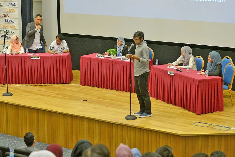 PERTANDINGAN BAHAS: Pasukan pelajar dari NUS dan NP berbahas dengan mauduk 'Masyarakat Islam di Singapura tidak proaktif menentang radikalisme' dalam satu pertandingan anjuran cabang belia Persatuan Darul Arqam di MDIS kelmarin. - Foto TUKIMAN WARJI
