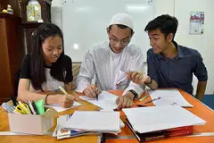TUISYEN DI MASJID DAN GEREJA: Wynne Choo (kiri) dan Muhammad Khairul Amshar Anuar (kanan) merupakan antara peserta program tuisyen anjuran Masjid Khalid dan Gereja Heart of God. Antara tutor sukarelawan yang membantu menjayakan program tersebut termasuk Encik Amirul Muttaqin Aduka (tengah). - Foto BH oleh Jasmine Choong