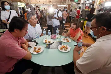 SOKONGAN BAGI PENJAJA: Dr Khor berkata pemerintah komited memberi sokongan kepada penjaja meneruskan perniagaan mereka. Beliau berada di pusat penjaja Ghim Moh semalam bersama (dari kiri) pengerusi bersama kumpulan bertugas bagi memberi sokongan kepada penjaga, Encik Edward Chia, yang juga AP GRC Holland-Bukit Timah; dan pengerusi Persatuan Penjaja Chinatown Compex, Encik Lim Gek Meng; serta seorang penjaja. - Foto ZAOBAO