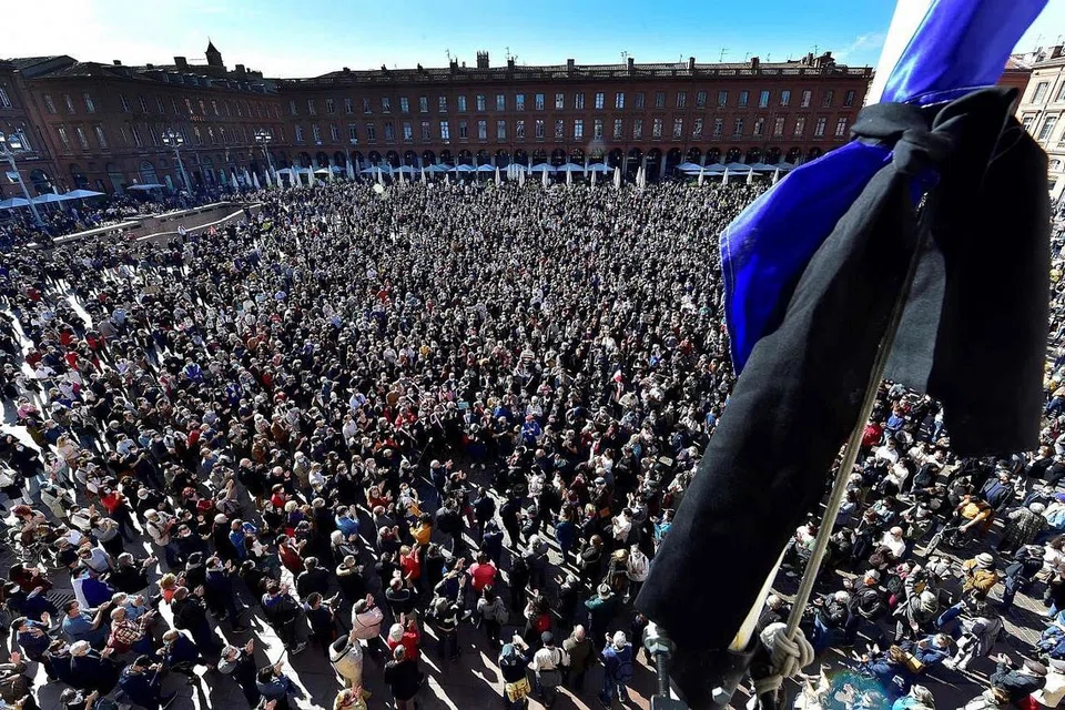 BERHIMPUN TANDA PERPADUAN: Ribuan orang membanjiri Place du Capitole di Toulouse kelmarin memberi penghormatan kepada guru sejarah Samuel Paty yang dibunuh. - Foto AFP