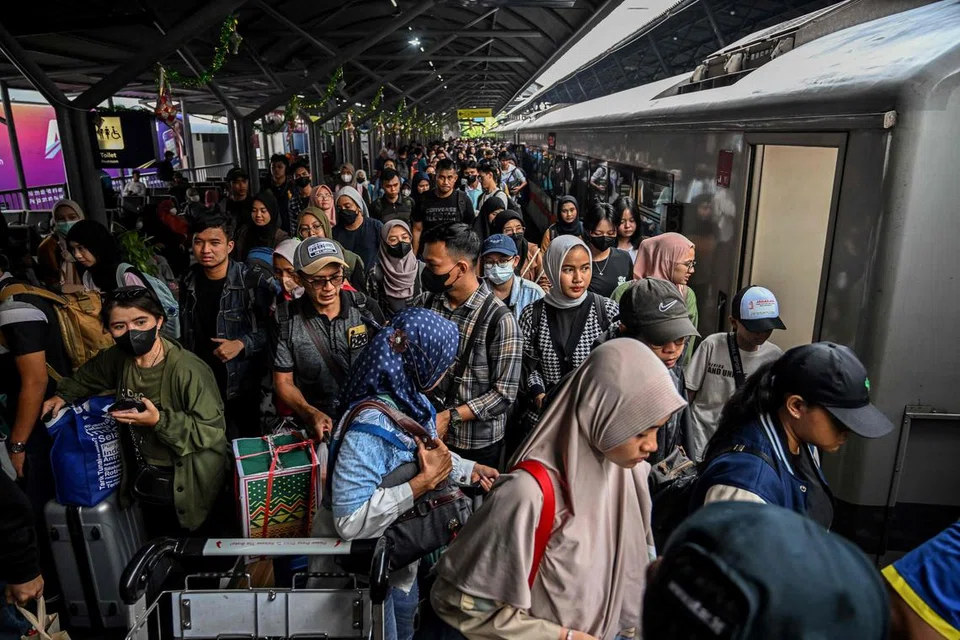 Para penumpang menaiki kereta api untuk pulang ke kampung menjelang Aidilfitri  di stesen Gubeng di Surabaya pada 7 April sedang ulama Indonesia sepakat memutuskan tarikh menyambut Hari Raya pada 10 April