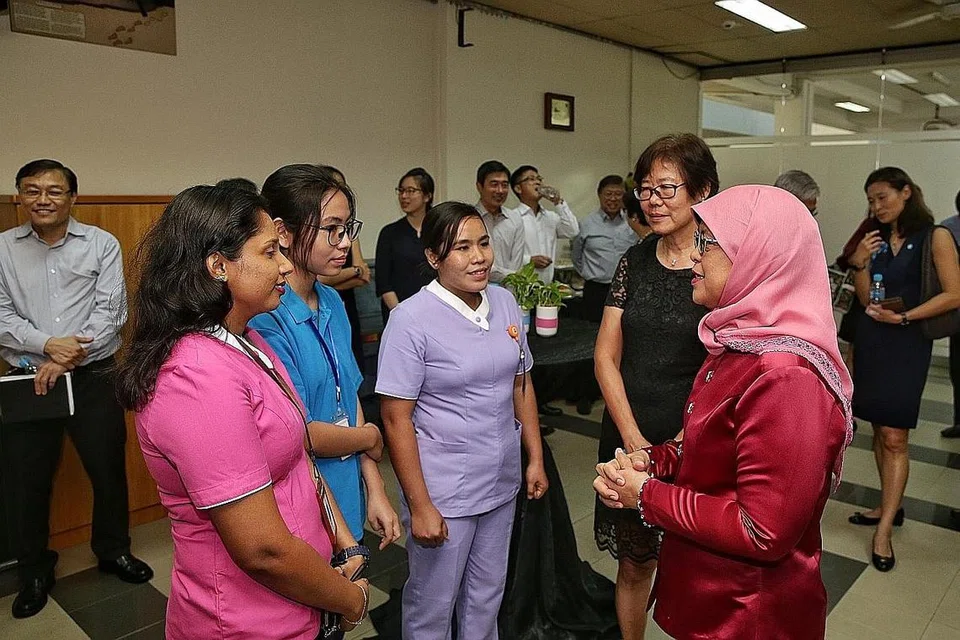 HARGAI PEKERJA KESIHATAN: Presiden Halimah, diiringi Pengarah Kejururawatan Rumah Ling Kwang Home bagi Warga Emas, Cik Lee Geok Yian, beramah-tamah dengan pembantu jururawat dari Sri Lanka Kankanige Dona Menaka Chandani Jayarani, pembantu ahli fisioterapi dari Myanmar Thinzar Hlaing, dan jururawat dari Myanmar Ei Ei Toe - Foto BH oleh KEVIN LIM