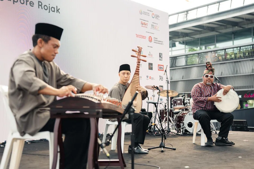 Encik Mohamed Faizal (kiri); pemain pipa (gitar Cina), Encik Chin Yen Chien @ Muhammad Shafeeq Chin dan pemain tabla dan rebana, Encik Rudi Salim daripada kumpulan Singapore Rojak membuat persembahan medley lagu berbagai bahasa termasuk lagu popular, ‘Rasa Sayang’,’Can’t Help Falling in Love’ dan lagu Cina, ‘The moon represents my heart’. 