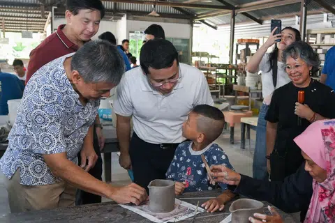 Acara pembukaan rasmi Potter’s Garden turut merangkumi lawatan berpandu yang dikendalikan oleh penggiat seni tembikar, Dr Suriani Suratman (dua dari kanan). Dalam ucapannya, Menteri Pendidikan dan Anggota Parlimen (MP) GRC West Coast-Jurong West, Encik Desmond Lee (berbaju putih di tengah), menjelaskan tentang peranan kawasan itu sebagai ruang yang mengekalkan warisan seni tembikar yang telah lama bertapak di Jurong. 