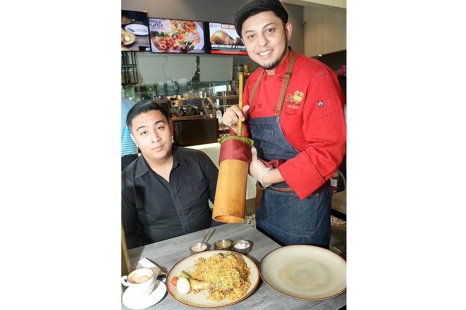 RASA BERBEZA: Cef Syed Shah (kanan) bersama seorang pengunjung restoran, menunjukkan nasi beriani rekaannya yang dimasak di dalam buluh dan merupakan gabungan bahan dari tiga negara - India, Australia dan Pakistan. Ia kini terdapat di restoran 99Bistro di Institut Pembelajaran Sepanjang Hayat berdekatan stesen MRT Paya Lebar. - Foto JOHARI RAHMAT