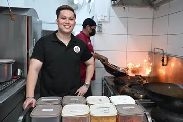 Dahulu seorang pramugara selama sekitar lima tahun, Encik Hadi Hazman (depan) kini menguruskan perniagaan katering keluarganya, Pondok Selera Catering Services, yang ditubuhkan pada 2023.