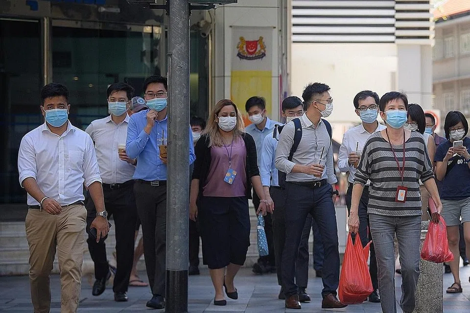 KEMBALI KE TEMPAT KERJA SECARA SELAMAT: Pekerja memakai pelitup menunggu untuk menyeberang jalan di Kawasan Pusat Bandar pada waktu makan tengah hari. Lebih ramai pekerja akan dibenarkan kembali ke tempat kerja, meskipun langkah pengurusan selamat perlu dilaksana. - Foto BH oleh MARK CHEONG