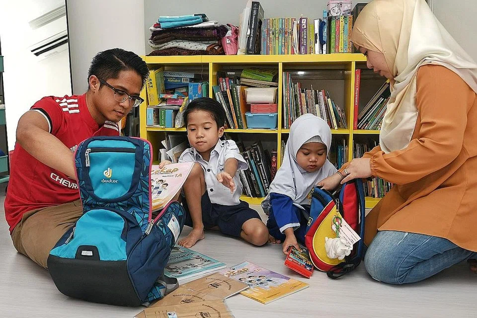 SIAPKAN BEG SEKOLAH: Cik Nurezma Farah dan suami, Encik Muhammad Tarmizi, membantu anak-anak mereka, Emir Zayd dan Enara Zakiia, mengemas beg bagi persiapan sekolah nanti. - Foto BM oleh KHALID BABA