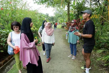 LOKASI UNIK: Encik Naqiuddin (kanan), pelayan restoran Poison Ivy, juga menjalankan peranan sebagai jurupandu pelancong di Bollywood Veggies dengan membawa pengunjung melawat ladang di situ dan menjalakan kegiatan menarik untuk mereka. - Foto JOHARI RAHMAT
