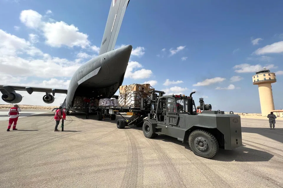 BANTUAN DARI UDARA: Relawan dari pertubuhan Sabit Merah Mesir dan Qatar kelihatan mengisi bekalan bantuan kemanusiaan bagi penduduk Gaza ke dalam sebuah pesawat di lapangan terbang el-Arish di Mesir.
