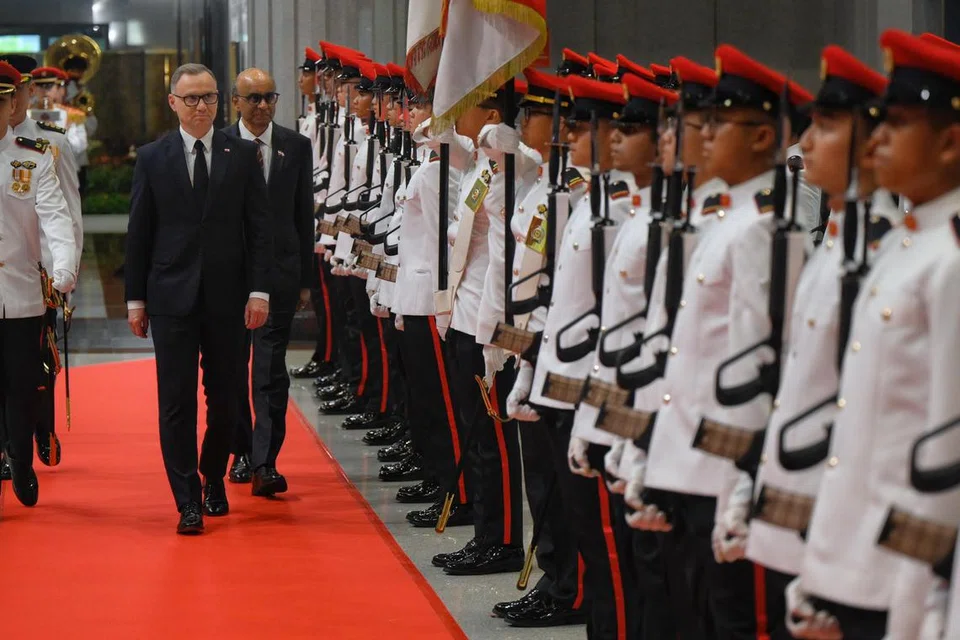 Presiden Poland, Encik Andrzej Duda (kiri), menerima sambutan istiadat ketika bertemu Presiden Tharman Shanmugaratnam, di Parlimen pada petang 12 Jun. 