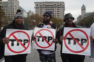 TEKANAN DALAM NEGERI: Beberapa orang membuat bantahan mengenai perjanjian Kerjasama Rentas Pasifik (TPP) di Washington, Amerika Syarikat, pada 14 November tahun lalu. - Foto-foto AFP