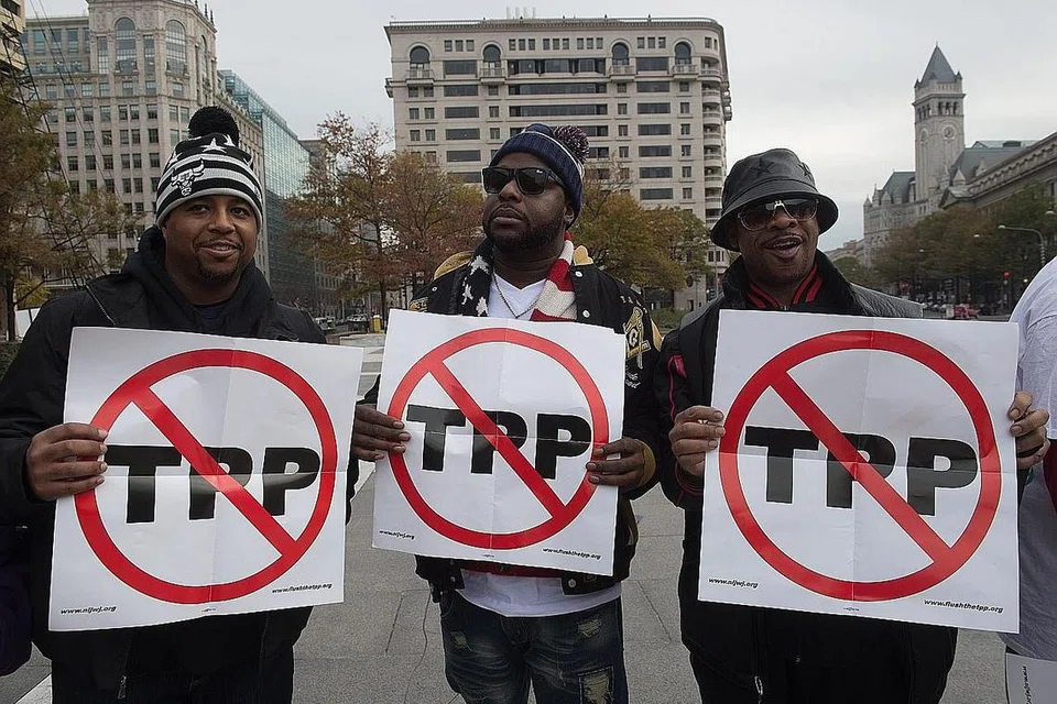TEKANAN DALAM NEGERI: Beberapa orang membuat bantahan mengenai perjanjian Kerjasama Rentas Pasifik (TPP) di Washington, Amerika Syarikat, pada 14 November tahun lalu. - Foto-foto AFP