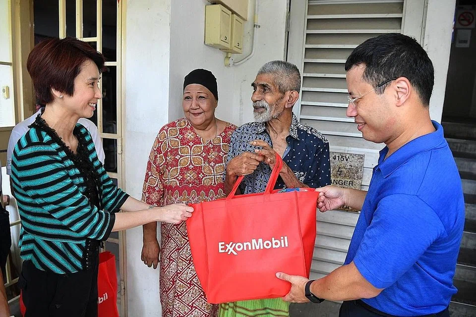 AGIH BANTUAN: Encik Desmond Lee (paling kanan) dan Cik Low Yen Ling (paling kiri) turun padang menyertai sukarelawan untuk mengagihkan habuan kepada penduduk di Boon Lay Cik Laila Abdullah (dua dari kiri) dan Encik Abdul Raheem Marican. - Foto BM oleh CHONG JUN LIANG