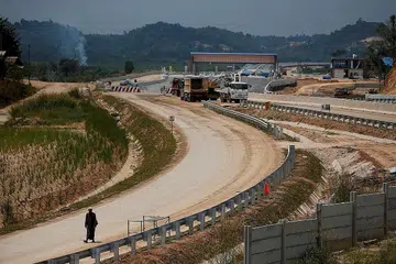 PROJEK BARU: Seorang lelaki kelihatan berjalan di tapak binaan jalan raya Balikpapan-Samarinda di Kabupaten Kutai Kertanegara, provinsi Kalimantan Timur, Indonesia. Pentadbiran Presiden Joko Widodo sedang mempertingkat usaha membangunkan prasarana di kawasan luar Pulau Jawa bagi mendorong pembangunan ekonomi di kawasan tersebut. - Foto REUTERS