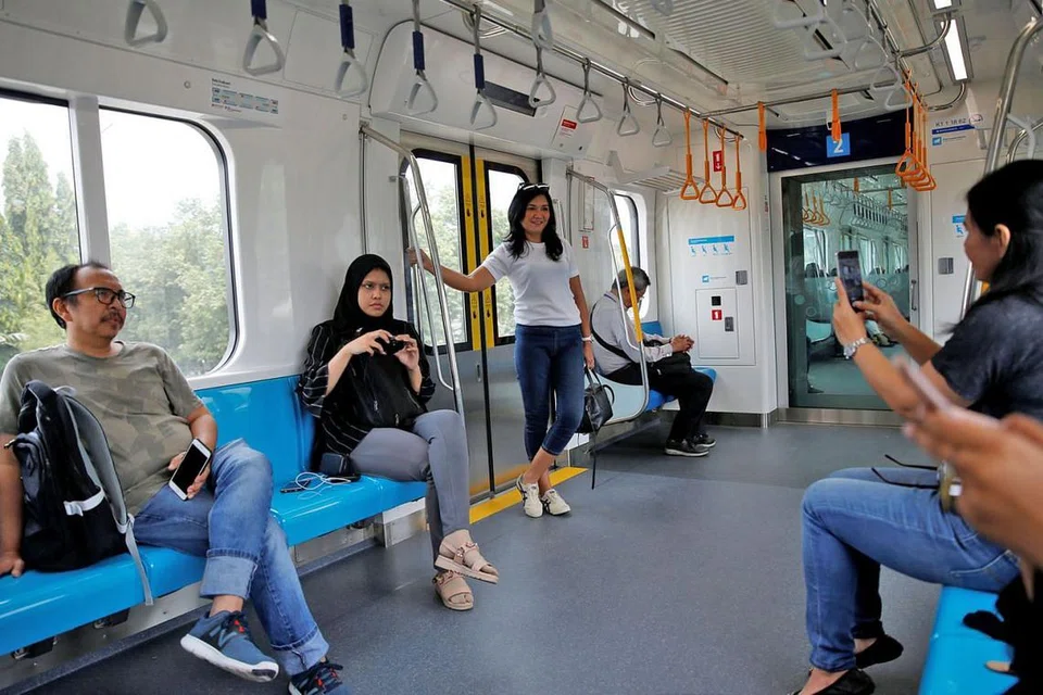 RAKAM DETIK BERSEJARAH: Penumpang merakam gambar kenangan semasa mencuba uji kereta api MRT Jakarta dan kemudahannya beberapa hari sebelum ia dibuka secara rasmi kepada orang ramai. - Foto REUTERS 