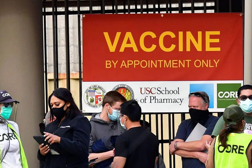 SEMAKIN RAMAI DIBERI VAKSIN: Orang ramai yang mengenakan pelitup beratur di depan pusat kemudahan vaksinasi Covid-19 di Los Angeles kelmarin. - Foto AFP