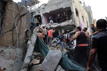 USAHA MENYELAMAT DITERUSKAN: Para penduduk Palestin giat mencari dan menyelamatkan mangsa yang mungkin terperangkap dI bawah puing runtuhan ekoran pengeboman Israel ke atas Rafah, di selatan Gaza, baru-baru ini.