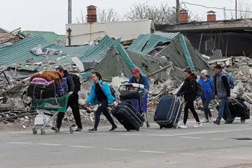 LARIKAN DIRI: Penduduk di Mariupol bergegas meninggalkan kediaman mereka setelah bandar pelabuhan timur Ukraine itu teruk diserang tentera Russia. - Foto REUTERS