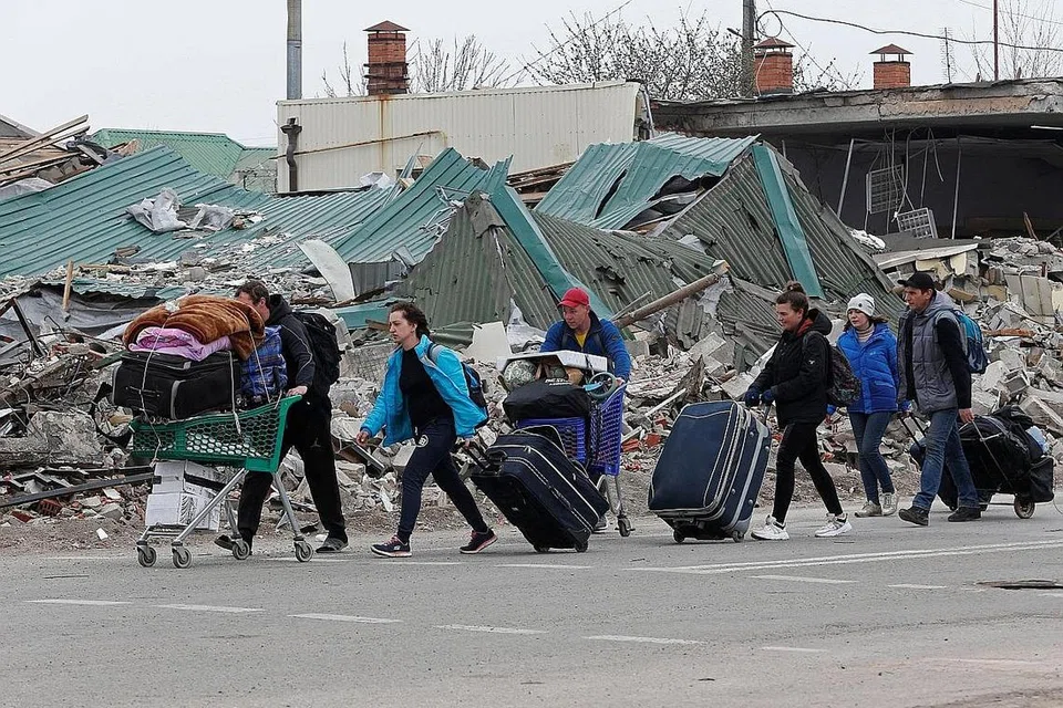 LARIKAN DIRI: Penduduk di Mariupol bergegas meninggalkan kediaman mereka setelah bandar pelabuhan timur Ukraine itu teruk diserang tentera Russia. - Foto REUTERS