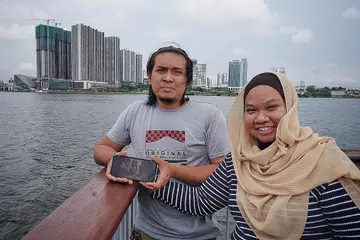 RINDU TERHADAP IBU TERCINTA: Selama dua tahun sempadan Singapura-Malaysia ditutup, Encik Hafiz dan isterinya, Cik Nurul Fai'qah, hanya dapat melihat gambar ibu Encik Hafiz, Cik Norbaiti Ibrahim di telefon, kerana ibunya tidak tahu memakai telefon bimbit pintar. - Foto BH oleh MOHD KHALID BABA