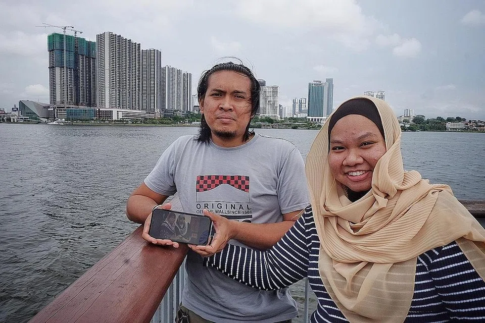 RINDU TERHADAP IBU TERCINTA: Selama dua tahun sempadan Singapura-Malaysia ditutup, Encik Hafiz dan isterinya, Cik Nurul Fai'qah, hanya dapat melihat gambar ibu Encik Hafiz, Cik Norbaiti Ibrahim di telefon, kerana ibunya tidak tahu memakai telefon bimbit pintar. - Foto BH oleh MOHD KHALID BABA