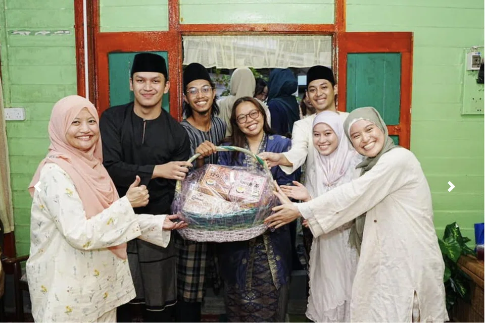 Editor Audiens dan Perkembangan Berita Harian (BH), Cik Norhaiza Hashim (kiri), menyampaikan hadiah kepada pemenang permainan berkumpulan di majlis perjumpaan Hari Raya anjuran ‘OMGxBH’ di Kampung Lorong Buangkok.