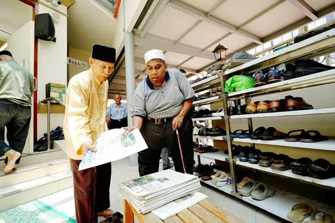 Encik Haji Mohamed Ali Haji Ahmad (kiri) dan Encik Osman V P Mohamed (kanan), turut menerima naskhah BH secara percuma di Masjid Khalid pada 17 April.