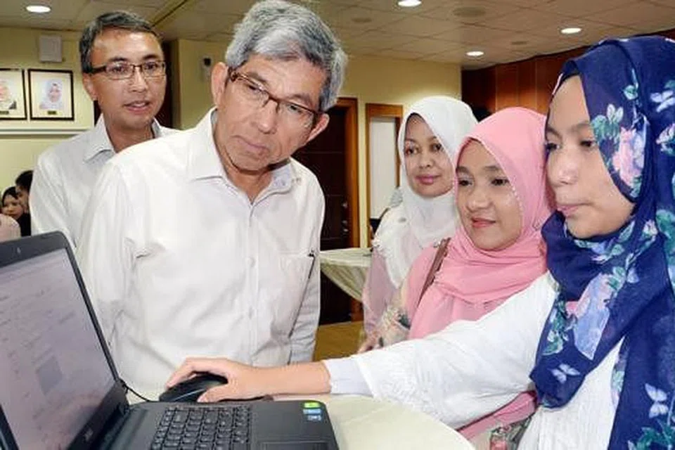 SISTEM BARU: Dr Yaacob Ibrahim (dua dari kiri) bersama Ketua Pegawai Eksekutif Yayasan Mendaki, Cik Tuminah Sapawi (tiga dari kanan), menyaksikan pelajar menggunakan sistem Skim Bantuan Kewangan Pengajian Tinggi (TFAS) yang baru dilancarkan bagi memohon Subsidi Yuran Tuisyen Pengajian Tinggi (TTFS) dalam talian semalam. - Foto JOHARI RAHMAT