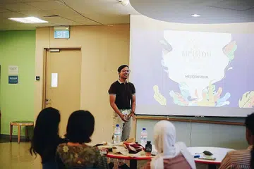 AKTIF DI UNI: Encik Danial (atas) membuat penyampaian semasa salah satu acara di NUS. Gambar diambil sebelum Covid-19. - Foto ihsan MUHAMMAD DANIAL JAMIL