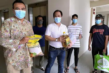 AGIH HABUAN: Encik Sharael (kiri) dan pengerusi Masjid Al-Istighfar, Encik Azman, bersama sukarelawan (belakang dari kiri) Zulkarnian Jumahat, Hilfi Haikel Zulkarnain dan Hariz Zikry Zulkarnain membantu mengagih habuan kepada benefisiari zakat. - Foto BM oleh NUR SYUHRAH HASSAN